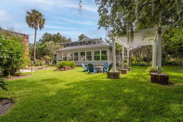 a view of a house with backyard and a tree