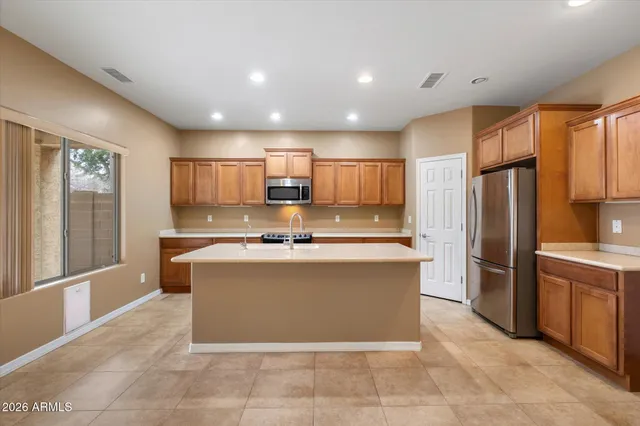a kitchen with stainless steel appliances granite countertop a stove refrigerator sink and microwave