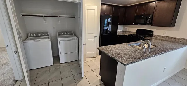 a kitchen with a sink a refrigerator and cabinets