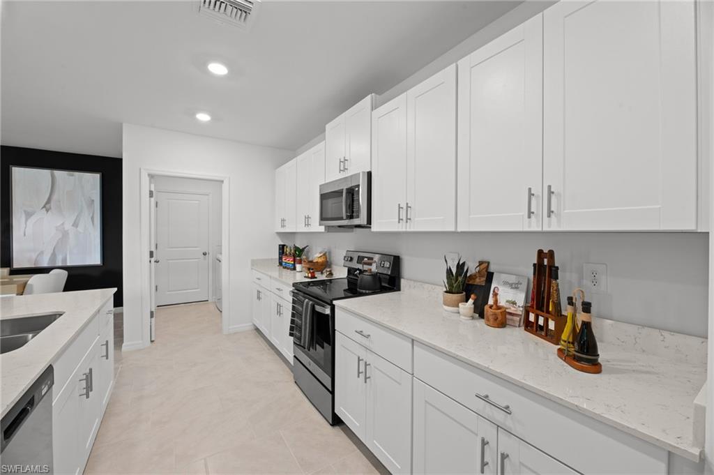7182 Sugar Pine Way Fort Myers, FL 33966 - Photo 15 of 36 a kitchen with stainless steel appliances white cabinets and a sink
