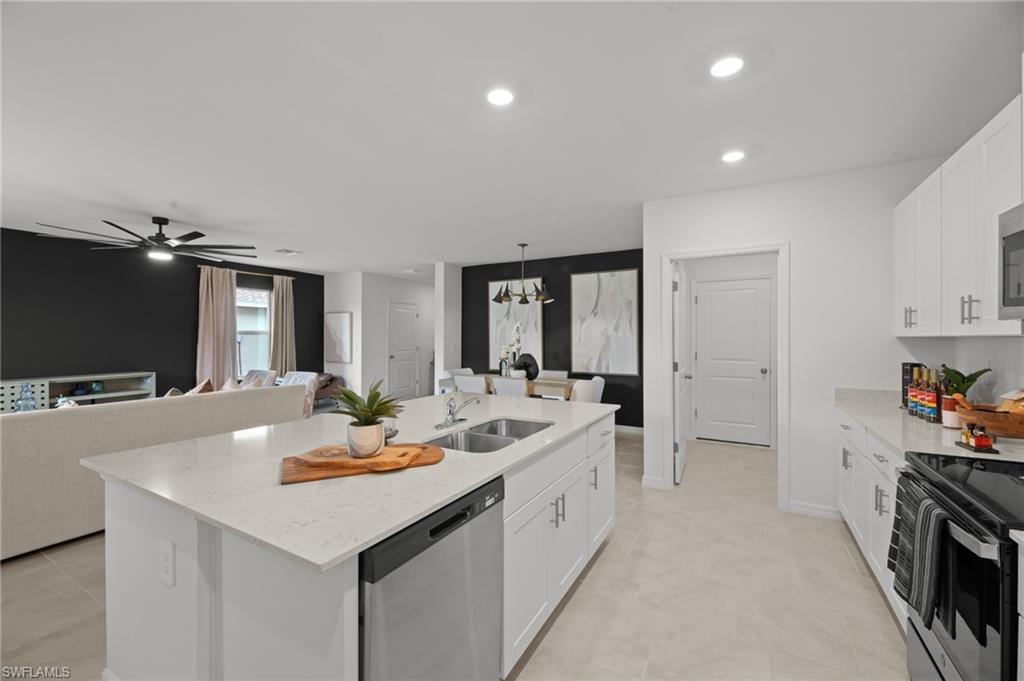 7182 Sugar Pine Way Fort Myers, FL 33966 - Photo 16 of 36 a large white kitchen with a sink and dishwasher a stove with wooden floor