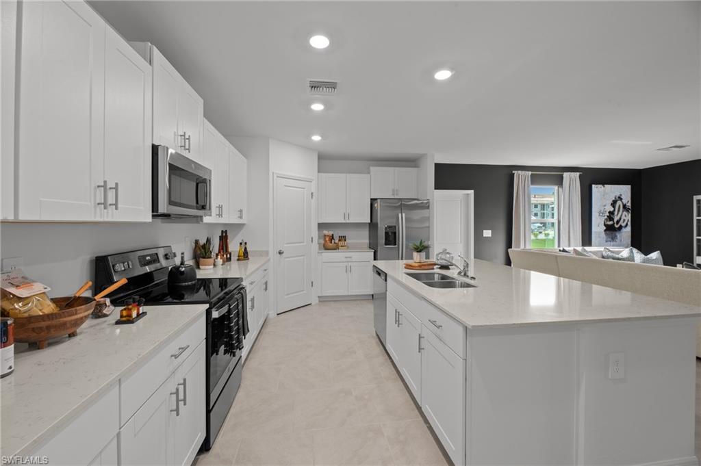 7182 Sugar Pine Way Fort Myers, FL 33966 - Photo 17 of 36 a kitchen with stainless steel appliances granite countertop a sink stove and refrigerator