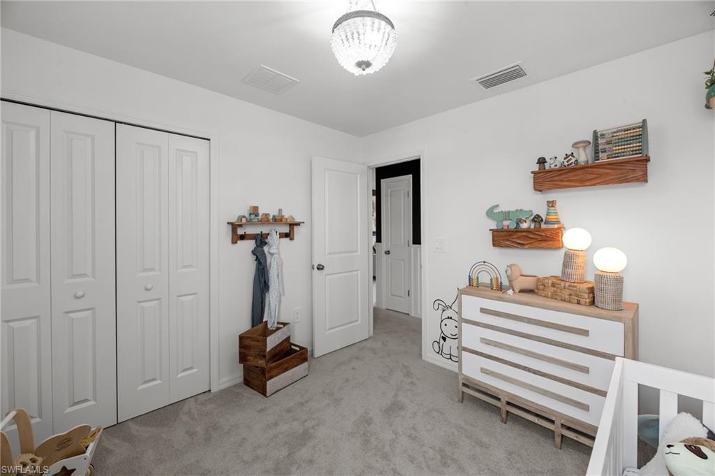 7182 Sugar Pine Way Fort Myers, FL 33966 - Photo 25 of 36 a bedroom with bed and a chandelier