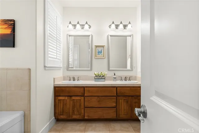 a view of a refrigerator in kitchen and an empty room with wooden floor