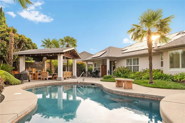 a view of a swimming pool with a patio and a yard with plants