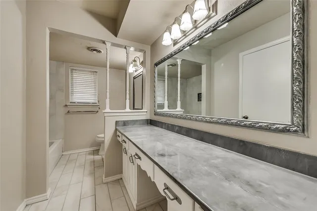 a bathroom with a granite countertop sink a mirror and a shower