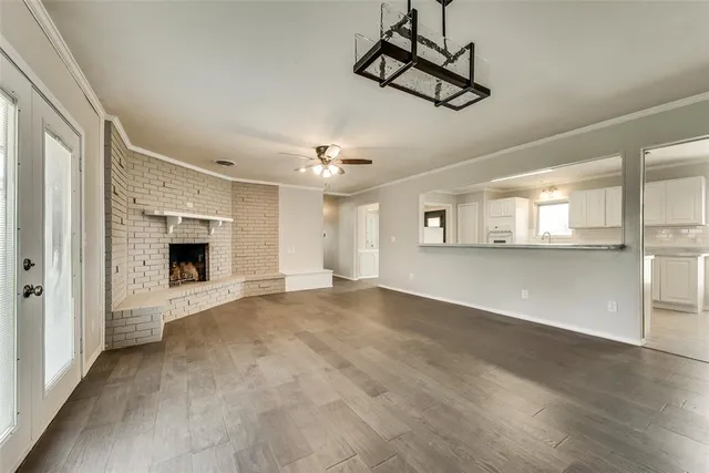a view of an empty room with a fireplace and window