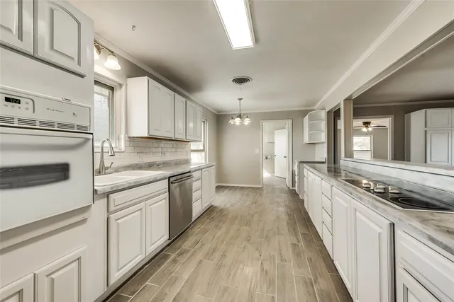 a view of a kitchen with a sink wooden floor and stainless steel appliances