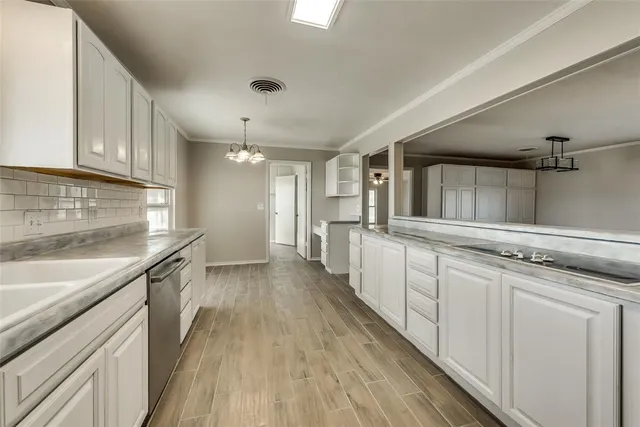 a large kitchen with cabinets and wooden floor