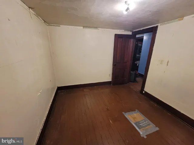 an empty room with wooden floor and closet