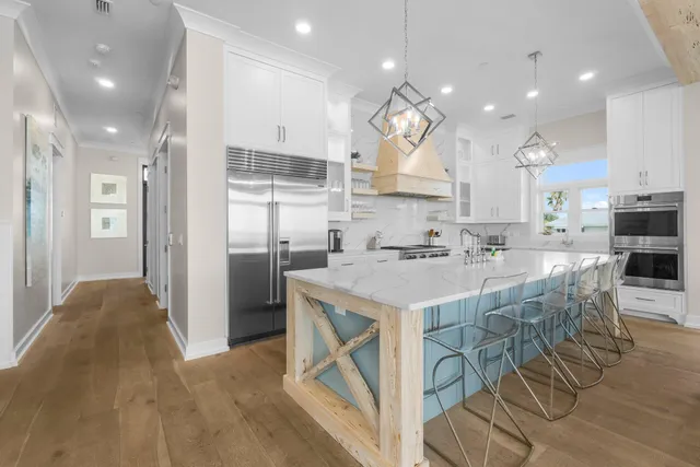 a kitchen with stainless steel appliances white cabinets and stove top oven