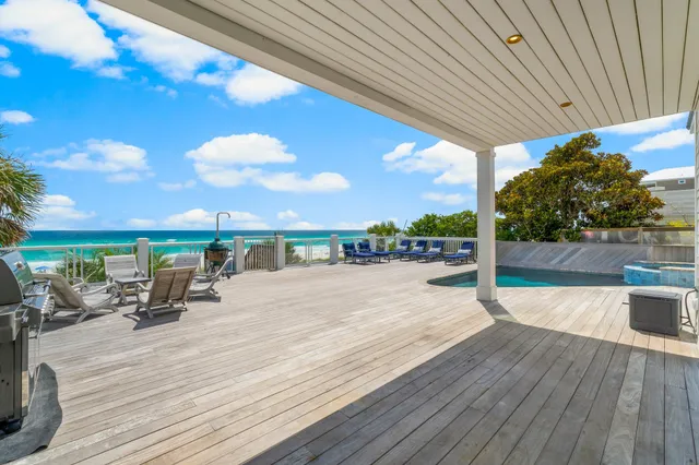 a kitchen with kitchen island granite countertop a sink a stove a refrigerator and a dining table with wooden floor