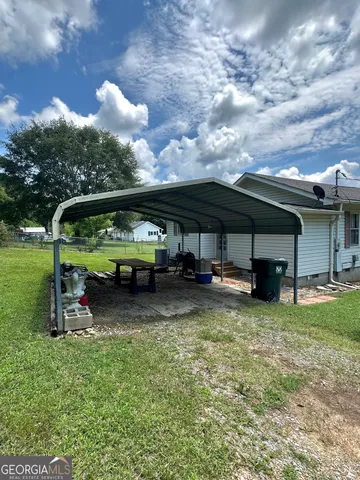 a view of a house with backyard and sitting area