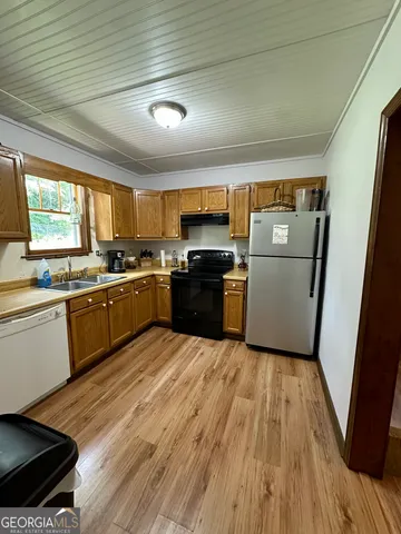 a kitchen with a sink a refrigerator a stove a microwave and cabinets