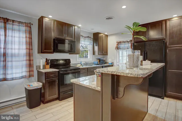 a kitchen with stainless steel appliances granite countertop a sink a stove and refrigerator