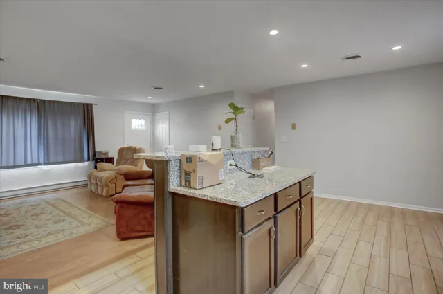 a kitchen with stainless steel appliances granite countertop a sink and a stove with wooden floor