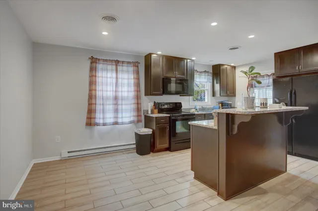 a kitchen with stainless steel appliances granite countertop a stove a sink a refrigerator and a microwave