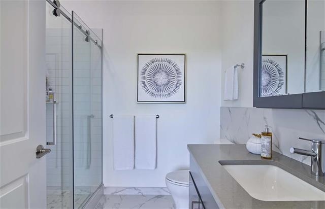 250 Ave East, Unit 611 Bayonne, NJ 07002 - Photo 7 of 17 a bathroom with a sink a toilet and shower