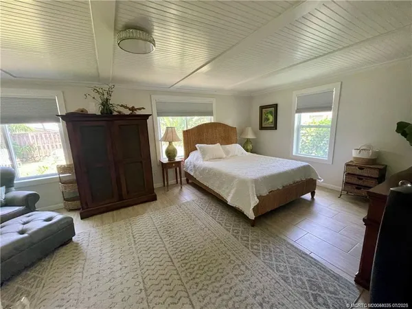 a bedroom with a bed and dresser with mirror