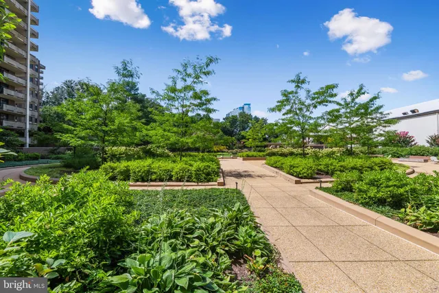 a view of yellow house with a flower garden