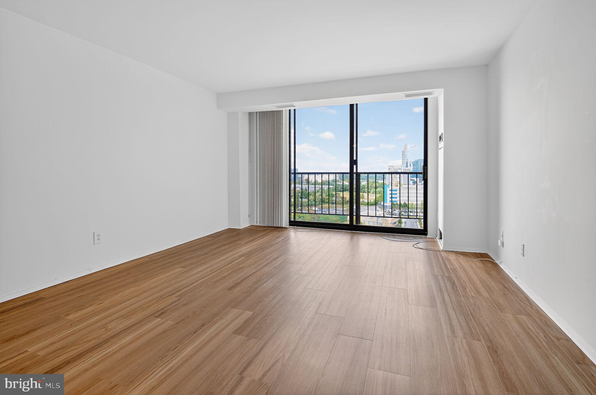 1800 Old Meadow Road, Unit 1415 McLean, VA 22102 - Photo 27 of 29 an empty room with wooden floor and windows