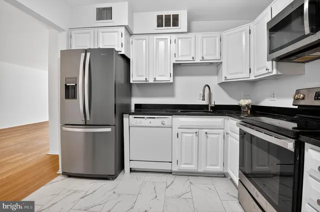 a kitchen with stainless steel appliances granite countertop a refrigerator sink and cabinets
