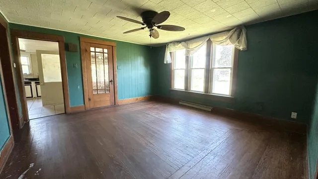a view of n empty room with window and wooden floor