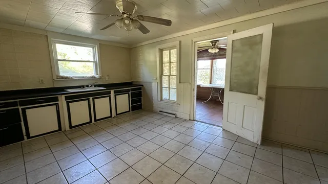 a view of an empty room with window and furniture