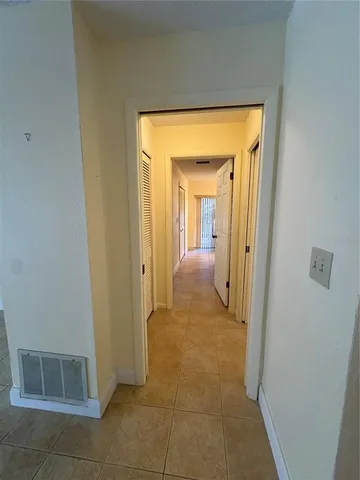 a view of a hallway with wooden floor and a livingroom