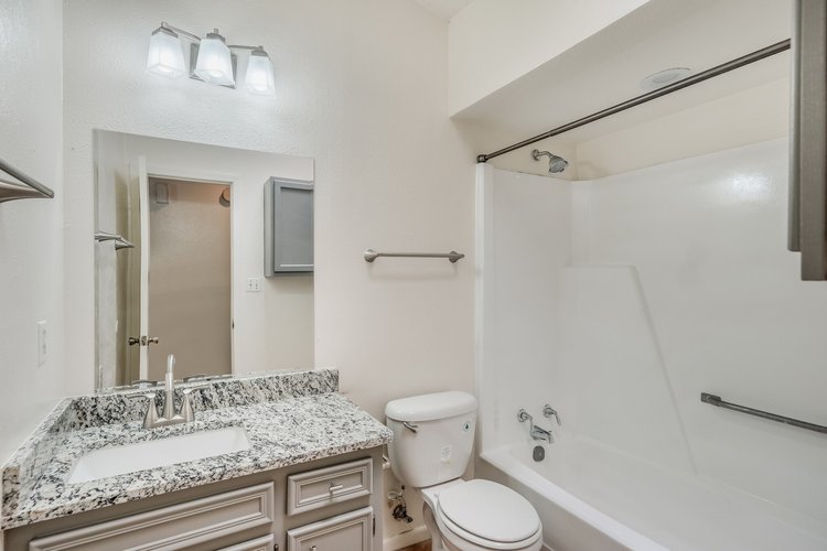 1102 Academy Street San Marcos, TX 78666 - Photo 13 of 17 a bathroom with a granite countertop sink toilet and shower