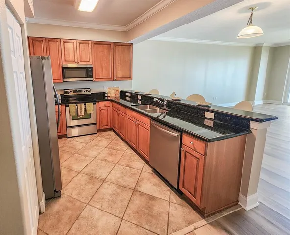 a kitchen with stainless steel appliances granite countertop a stove a sink and a refrigerator