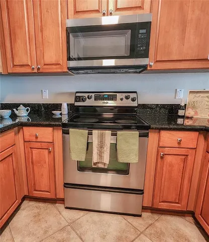 a kitchen with stainless steel appliances granite countertop wooden cabinets and a stove top oven
