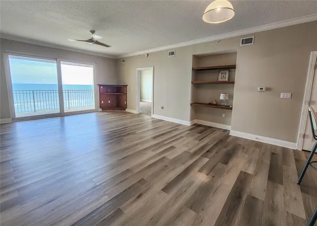 a view of empty room with wooden floor and cabinet