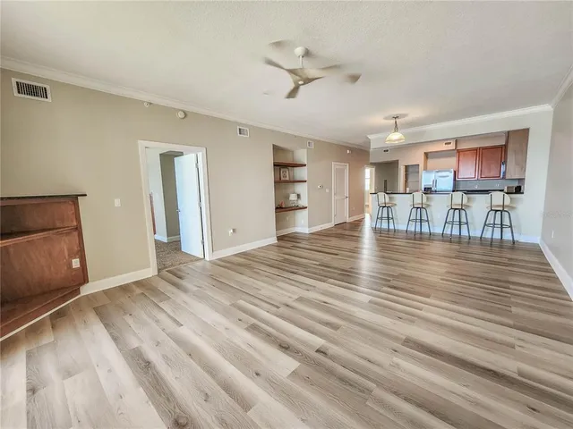 a view of empty room with kitchen and window