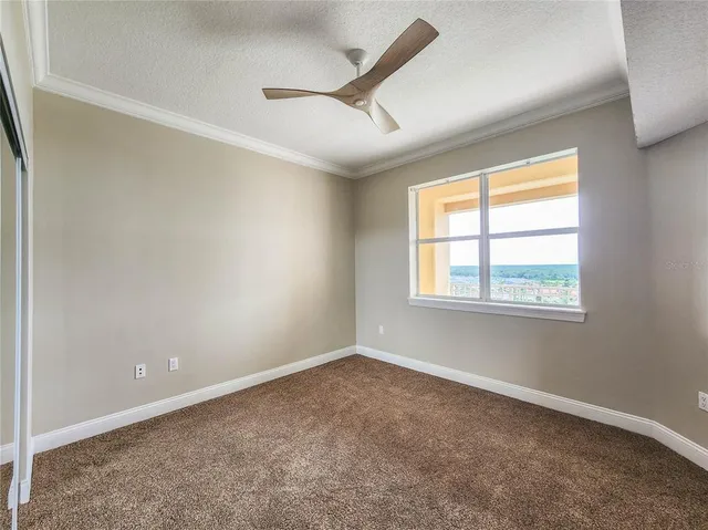 an empty room with a ceiling fan and windows