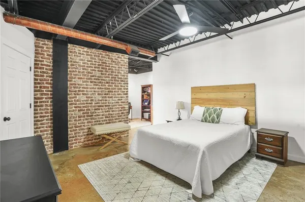 a large bedroom with a bed and wooden floor