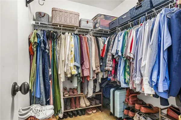 a view of walk in closet with clothes