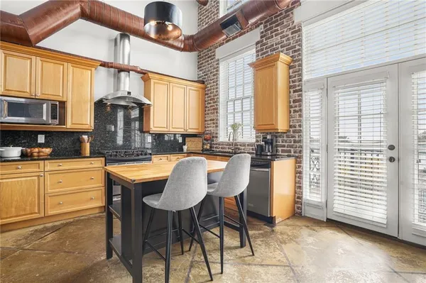 a kitchen with stainless steel appliances granite countertop a stove a sink and a refrigerator