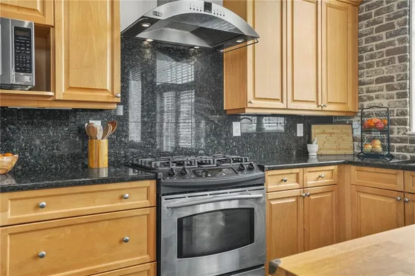 a kitchen with stainless steel appliances granite countertop a sink stove and cabinets