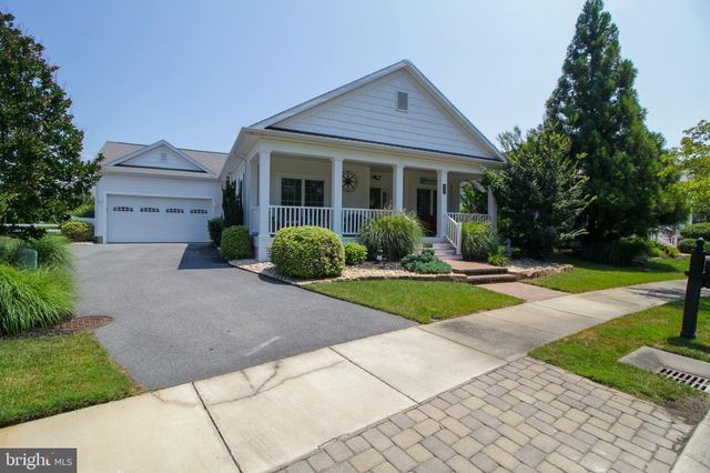 a front view of a house with yard and green space