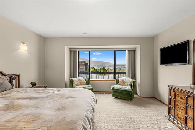 a bedroom with a bed and a large window