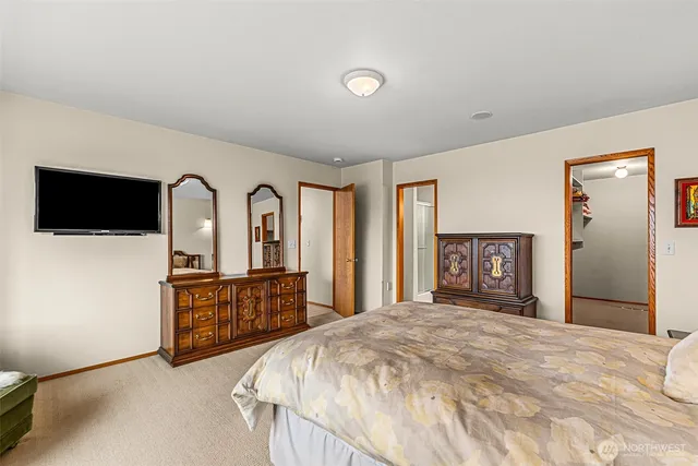 a bedroom with a bed and a flat screen tv on dresser