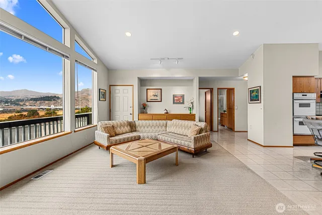 a living room with furniture and a floor to ceiling window