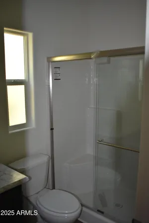 a bathroom with a toilet and a shower