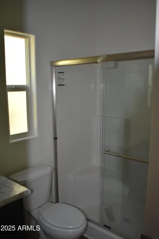 a bathroom with a toilet and a shower