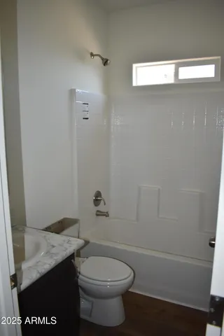 a bathroom with a granite countertop toilet and a sink