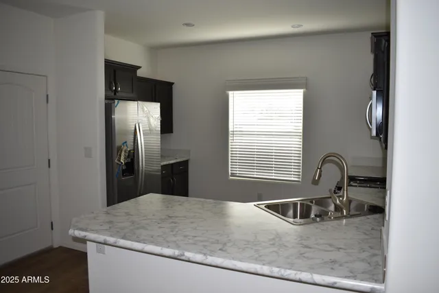 a kitchen with granite countertop a refrigerator and a sink