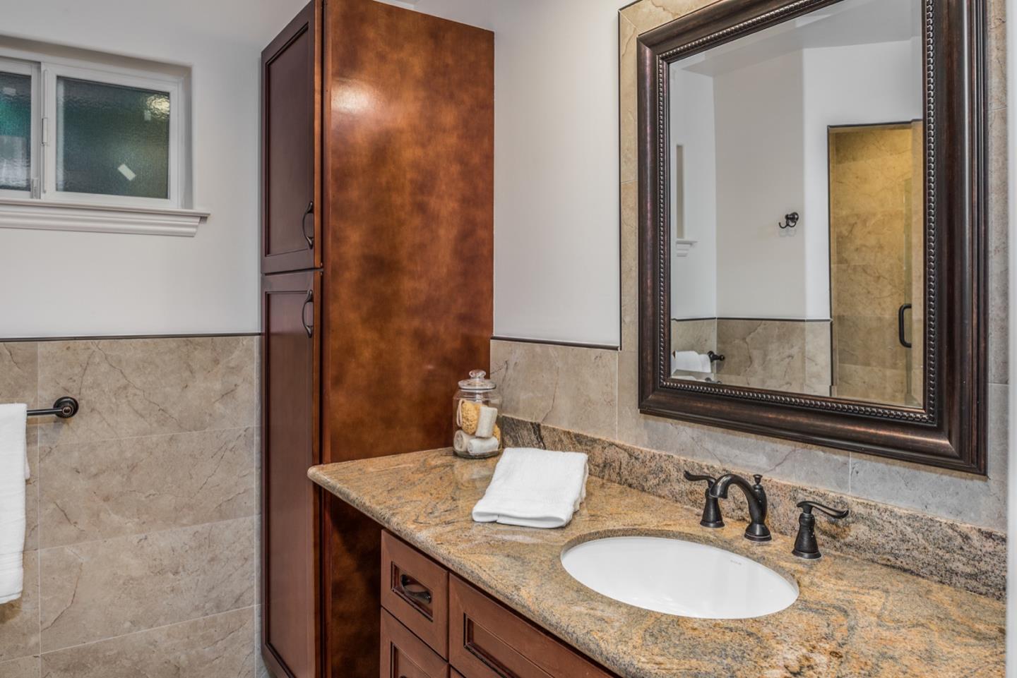 4157 Sunridge Road Pebble Beach, CA 93953 - Photo 18 of 25 a bathroom with a granite countertop sink and a mirror