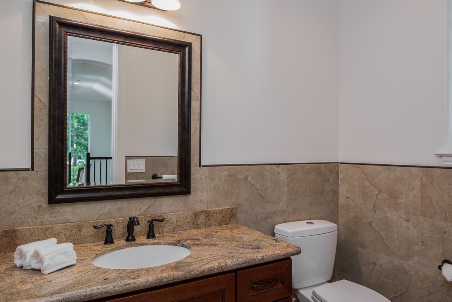 4157 Sunridge Road Pebble Beach, CA 93953 - Photo 23 of 25 a bathroom with a granite countertop sink and a mirror