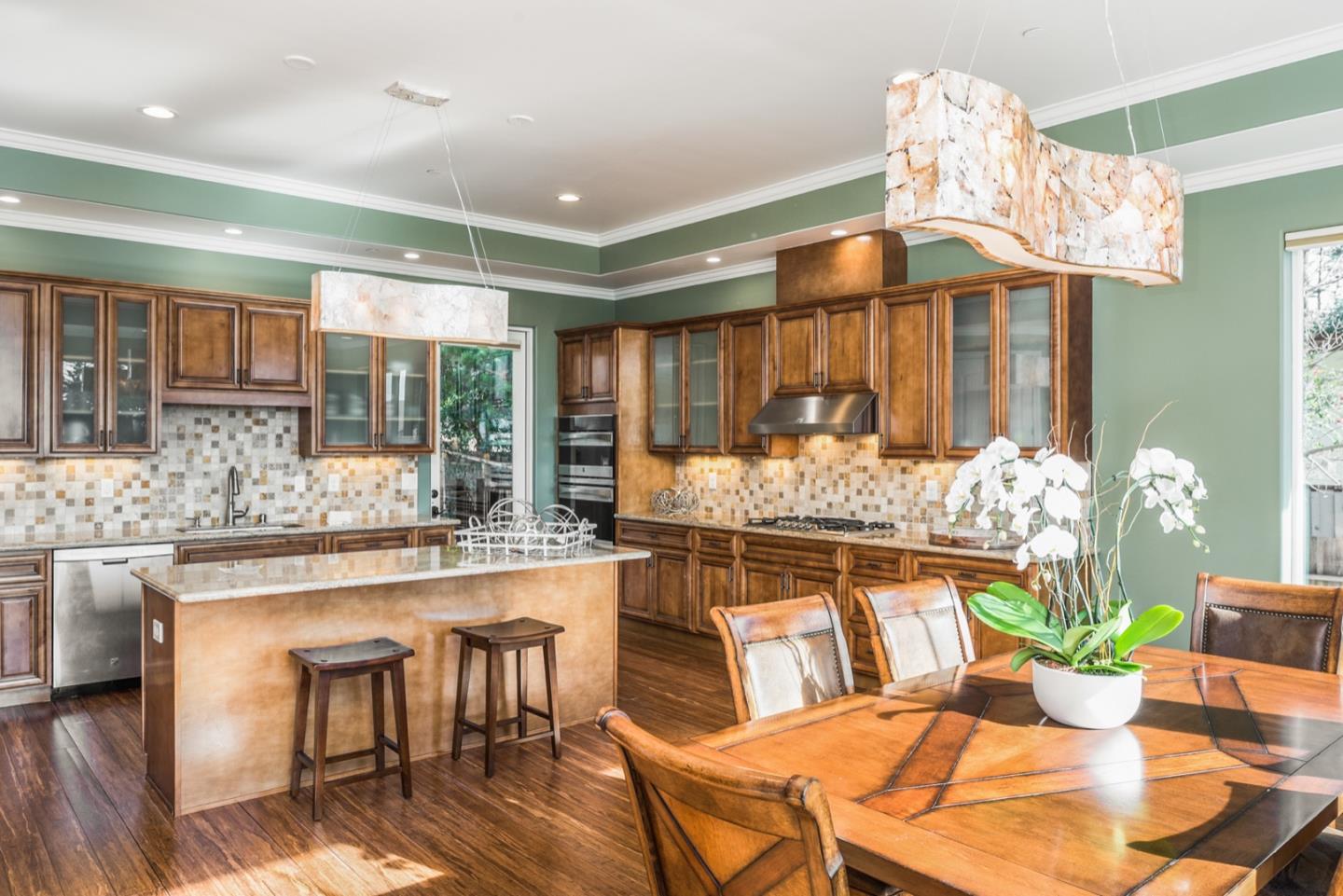 4157 Sunridge Road Pebble Beach, CA 93953 - Photo 3 of 25 a kitchen with stainless steel appliances kitchen island granite countertop a table and chairs in it